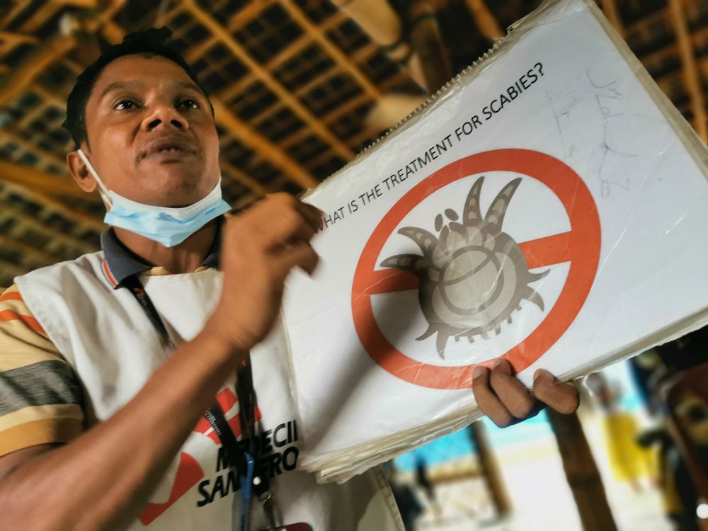 An MSF community-based health promotion volunteer raises awareness on scabies in the clinic’s waiting area.© MSF/Malvoisin