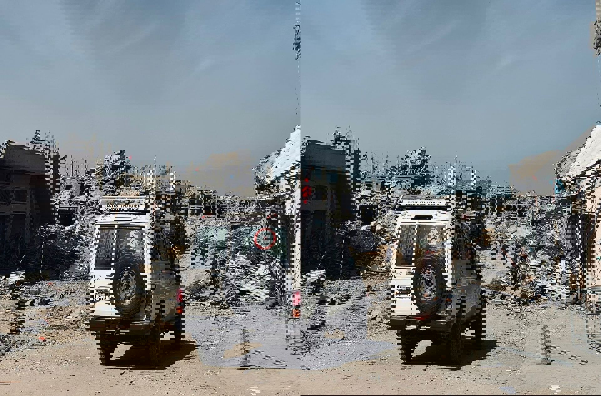 無國界醫生的車輛駛經加沙的一處廢墟,戰火為當地帶來嚴重破壞,重建路遙。