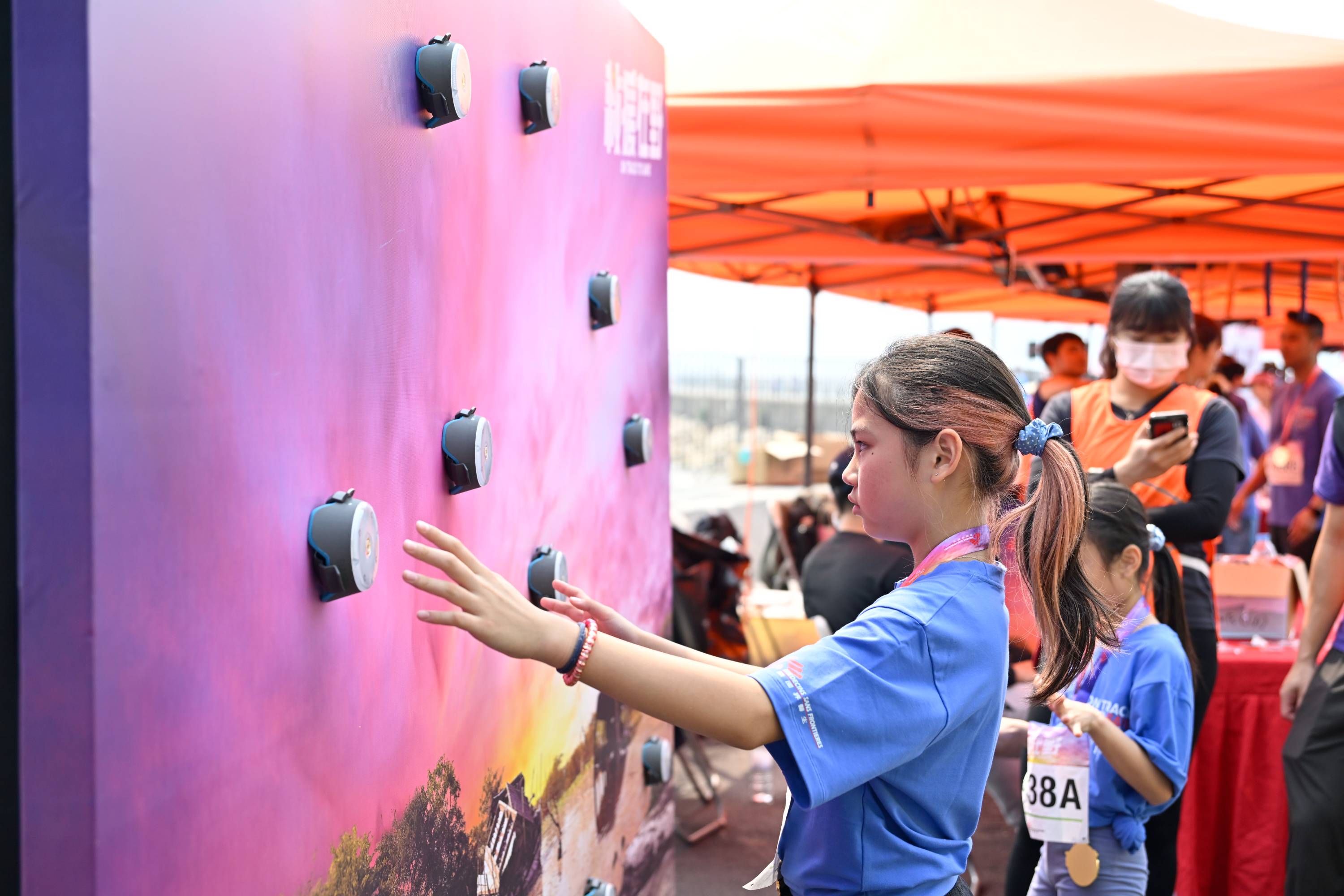 Photo shows a runner enjoying booth games that mirrored actual challenges faced by MSF field workers. (MSF)