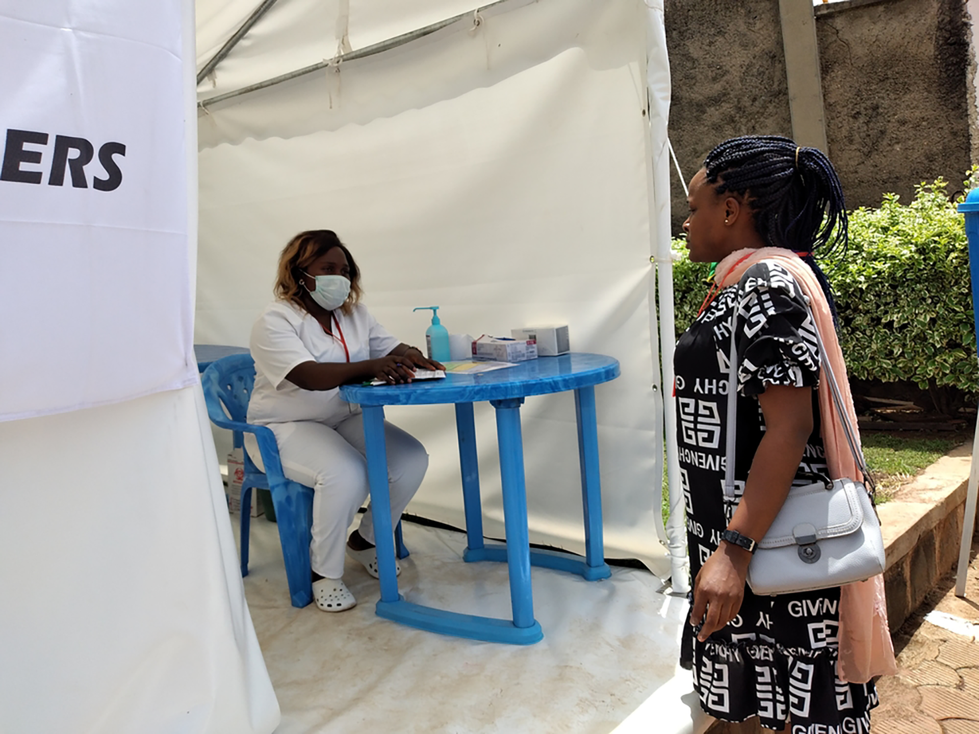 Visitors pass by the new COVID-19 pre-screening tent at the entrance of Bamenda&#039;s St Mary Soledad hospital. North West region, Cameroon, April 2020. © Freida Nemkul/MSF