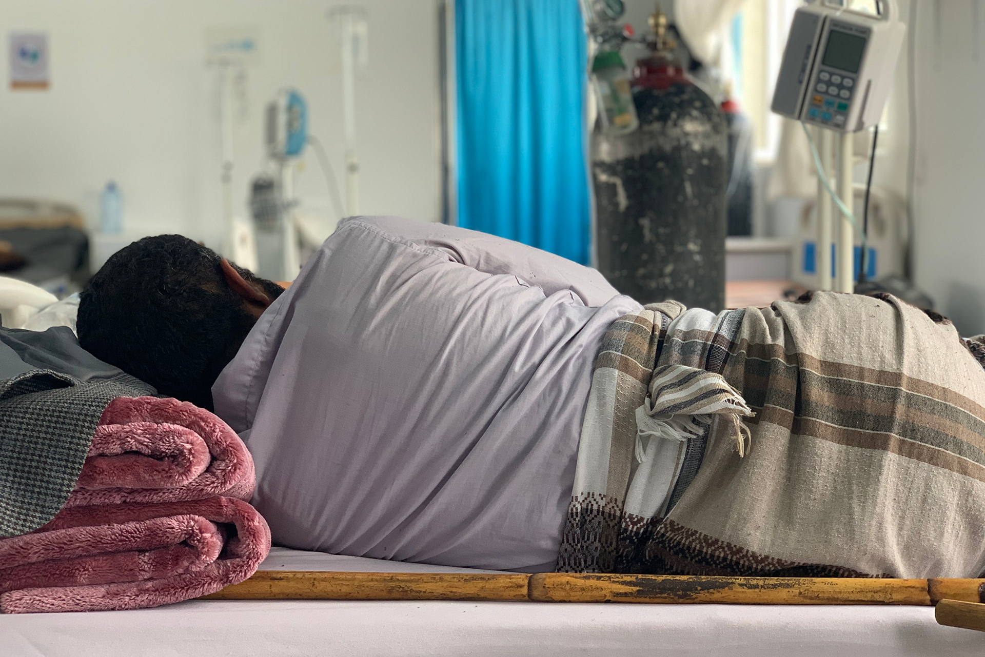 A patient receiving treatment lying in the male IPD room of the MSF-supported Sheikh Zayed COVID-19 center in Sana’a. © Maya Abu Ata/MSF 