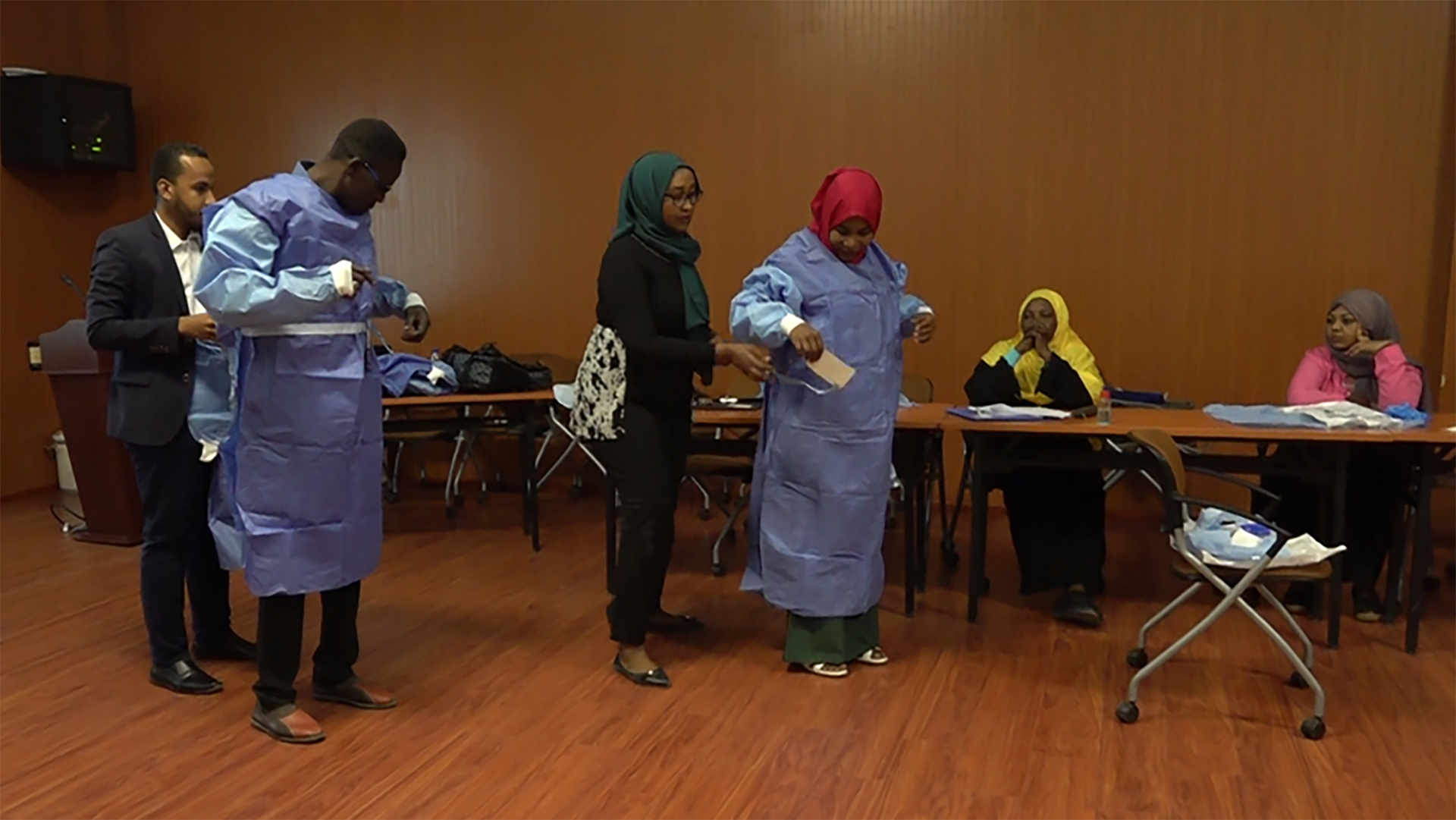 Sudanese healthcare professionals try to put on personal protection equipment (PPE) recommended to be used while assisting suspected COVID-19 patients, during a training arranged by MSF in collaboration with the Ministry of Health of Sudan and the World Health Organization. © Mudawi Hassan/MSF